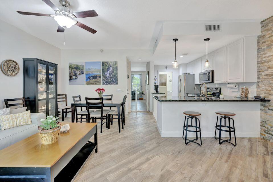 180 Freeport Drive Jupiter, FL 33458 - Photo 21 of 58 a living room with stainless steel appliances kitchen island granite countertop furniture and a kitchen view