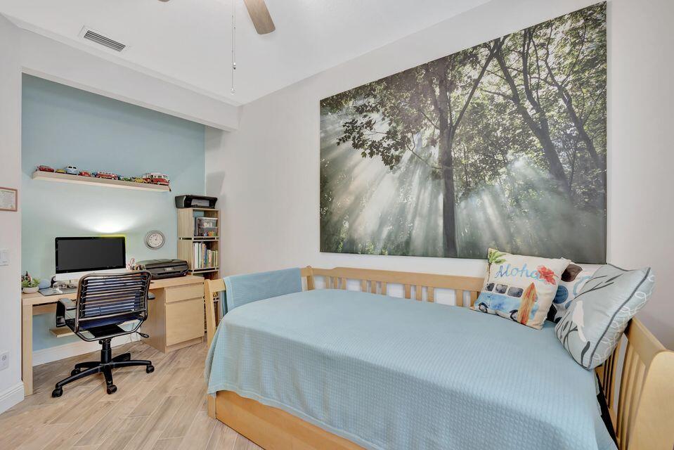 180 Freeport Drive Jupiter, FL 33458 - Photo 29 of 58 a bedroom with a bed and wooden floor