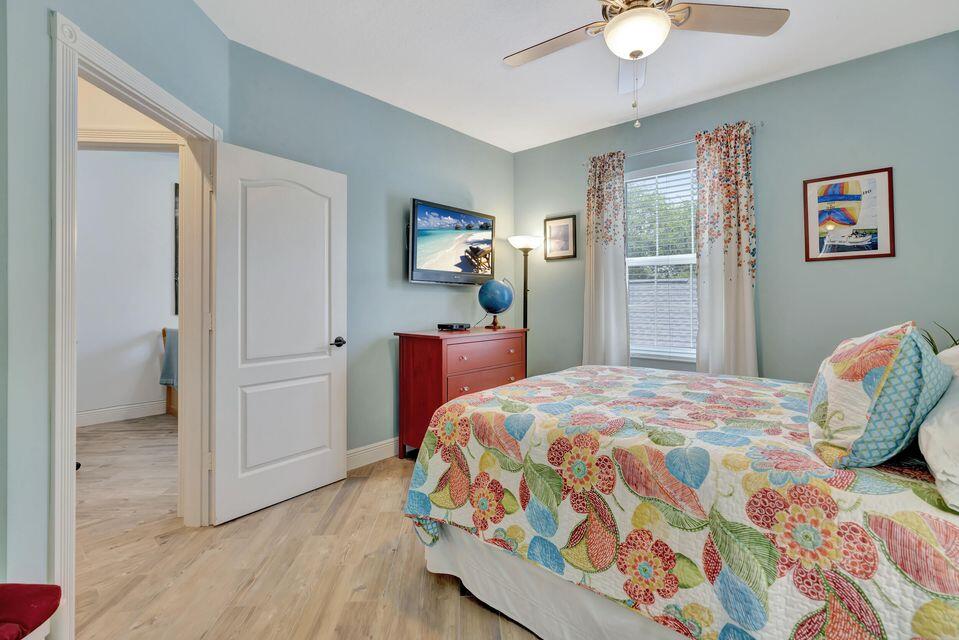 180 Freeport Drive Jupiter, FL 33458 - Photo 33 of 58 a bedroom with a bed and a chandelier