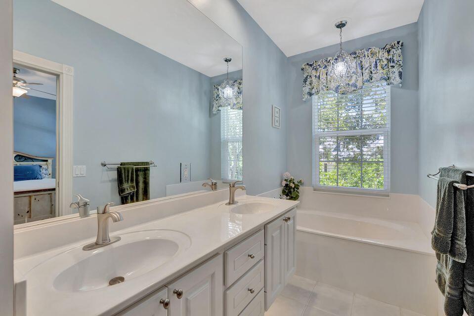 180 Freeport Drive Jupiter, FL 33458 - Photo 40 of 58 a bathroom with a tub sink and mirror