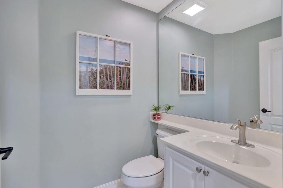 180 Freeport Drive Jupiter, FL 33458 - Photo 42 of 58 a bathroom with a toilet a sink and mirror