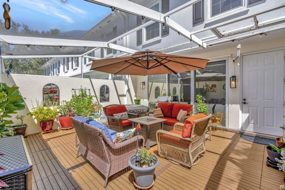 180 Freeport Drive Jupiter, FL 33458 - Photo 45 of 58 a view of a patio with a dining table and chairs under an umbrella