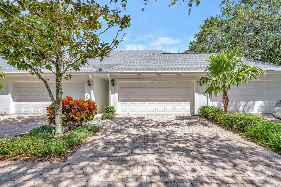 180 Freeport Drive Jupiter, FL 33458 - Photo 47 of 58 a front view of a house with a yard and a garage