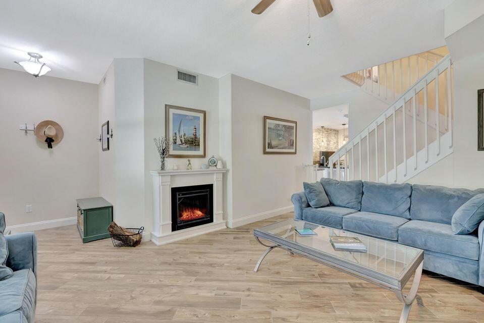 180 Freeport Drive Jupiter, FL 33458 - Photo 8 of 58 a living room with furniture a fireplace and a flat screen tv