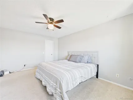 a bedroom with a bed and a ceiling fan