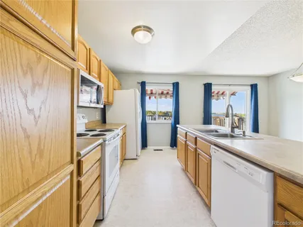 a large kitchen with stainless steel appliances granite countertop a lot of counter top space and wooden floor