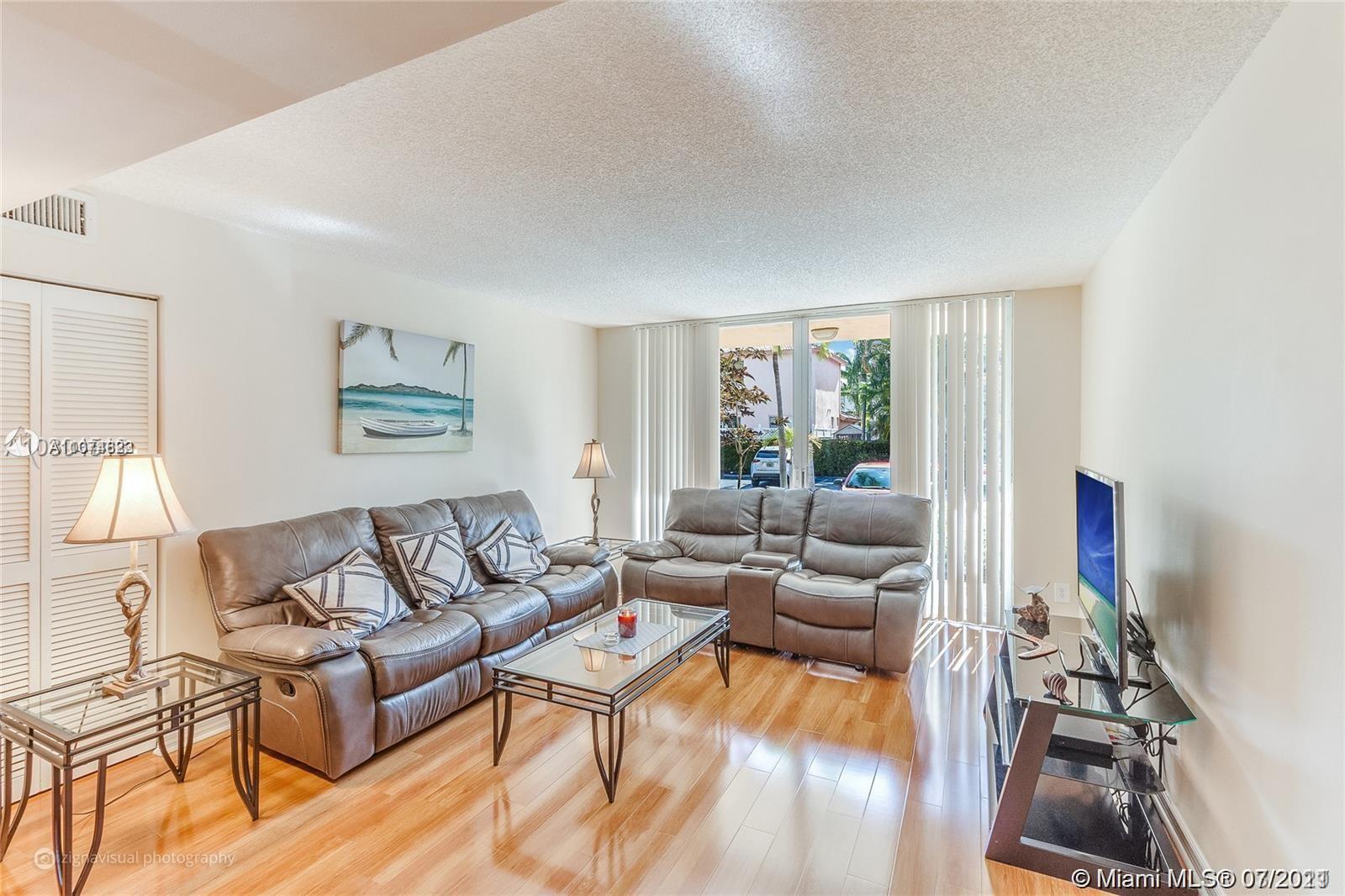 1450 Southeast 3rd Avenue, Unit 107 Dania Beach, FL 33004 - Photo 2 of 15 a living room with furniture and a large window