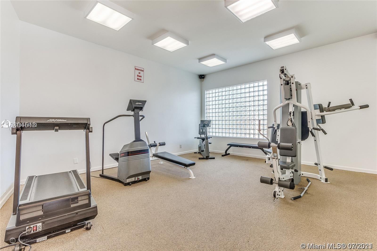 1450 Southeast 3rd Avenue, Unit 107 Dania Beach, FL 33004 - Photo 13 of 15 a room with gym equipment and a window