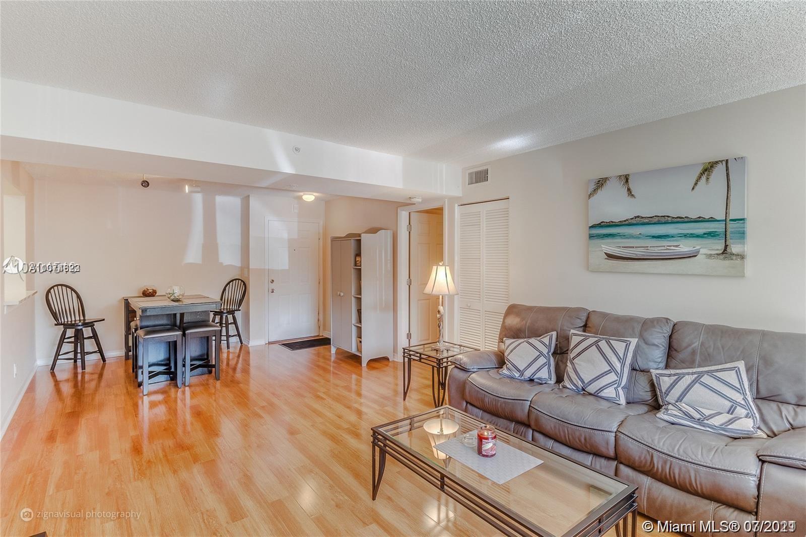 1450 Southeast 3rd Avenue, Unit 107 Dania Beach, FL 33004 - Photo 4 of 15 a living room with furniture and a wooden floor