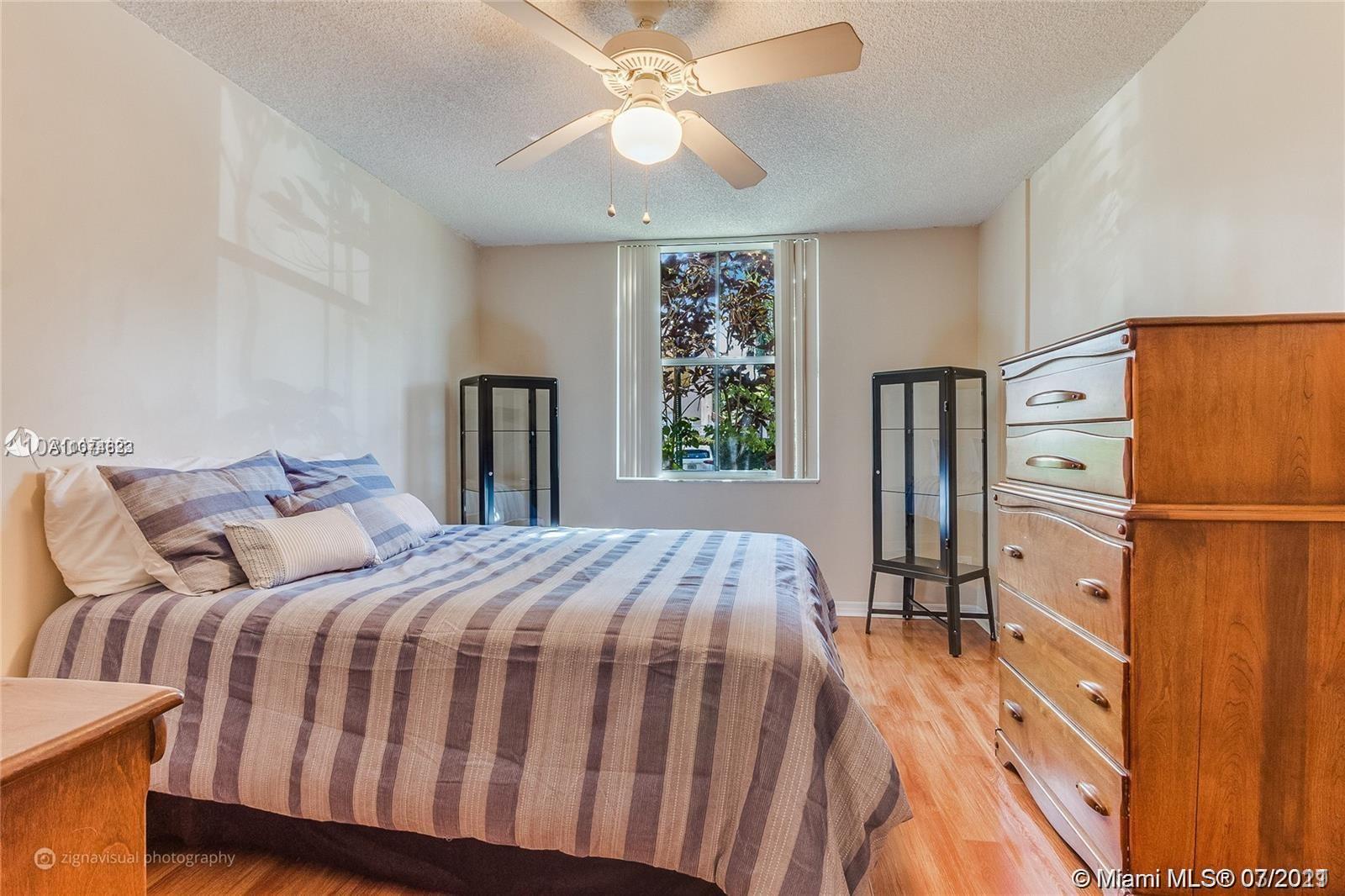 1450 Southeast 3rd Avenue, Unit 107 Dania Beach, FL 33004 - Photo 7 of 15 a bedroom with a bed dresser and a large window