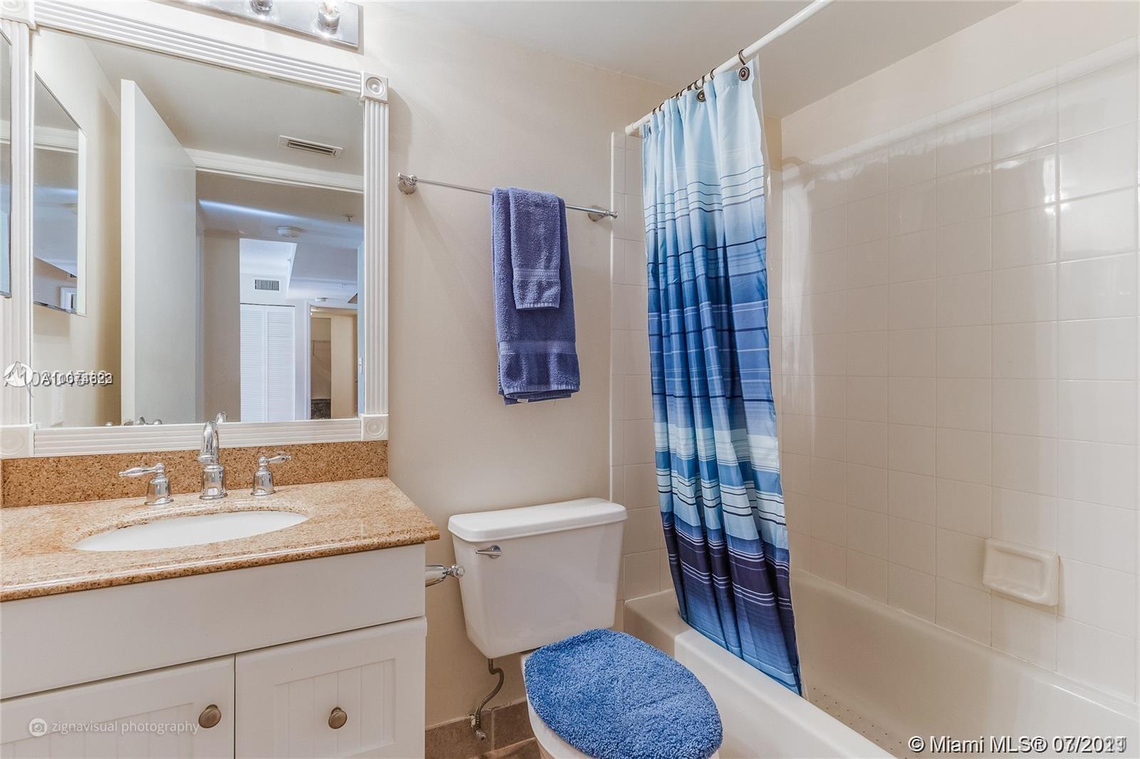 1450 Southeast 3rd Avenue, Unit 107 Dania Beach, FL 33004 - Photo 8 of 15 a bathroom with a granite countertop sink toilet and shower