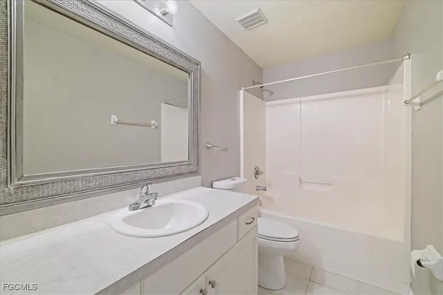 a bathroom with a toilet a sink a mirror a shower and vanity