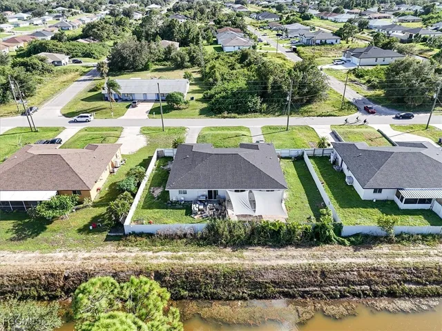 an aerial view of residential houses with outdoor space and swimming pool