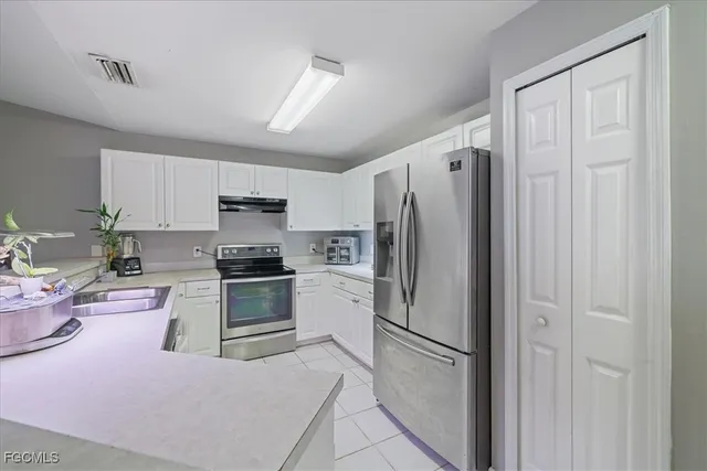 a kitchen with stainless steel appliances a refrigerator sink and cabinets