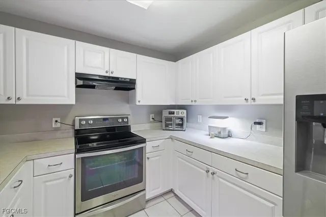 a kitchen with white cabinets and appliances