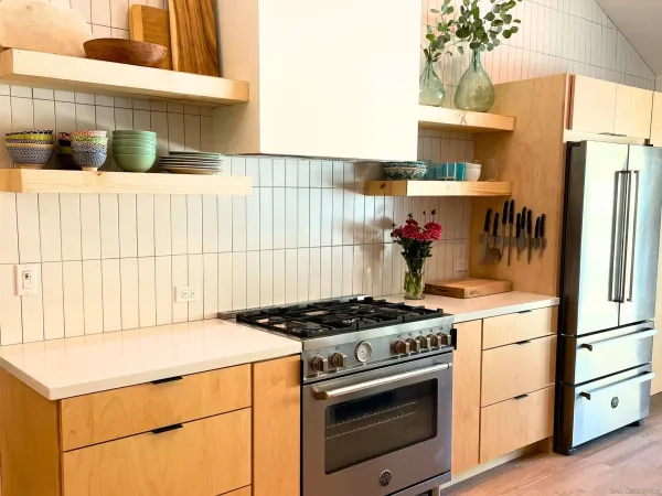 a kitchen with granite countertop a stove and a white refrigerator