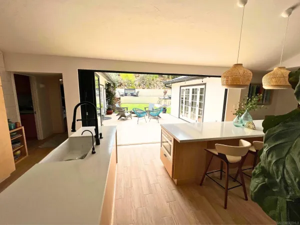 a living room with furniture a floor to ceiling window and wooden floor