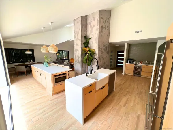 a large kitchen with stainless steel appliances a stove a sink dishwasher and cabinets with wooden floor