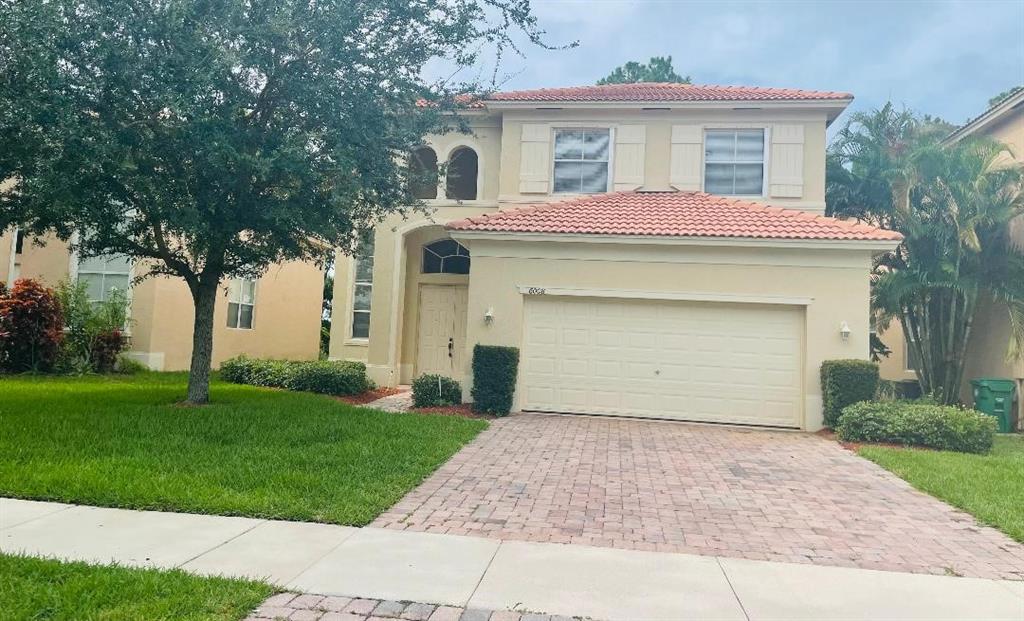 6008 Spring Lake Terrace Fort Pierce, FL 34951 - Photo 2 of 33 a front view of a house with a garden and trees