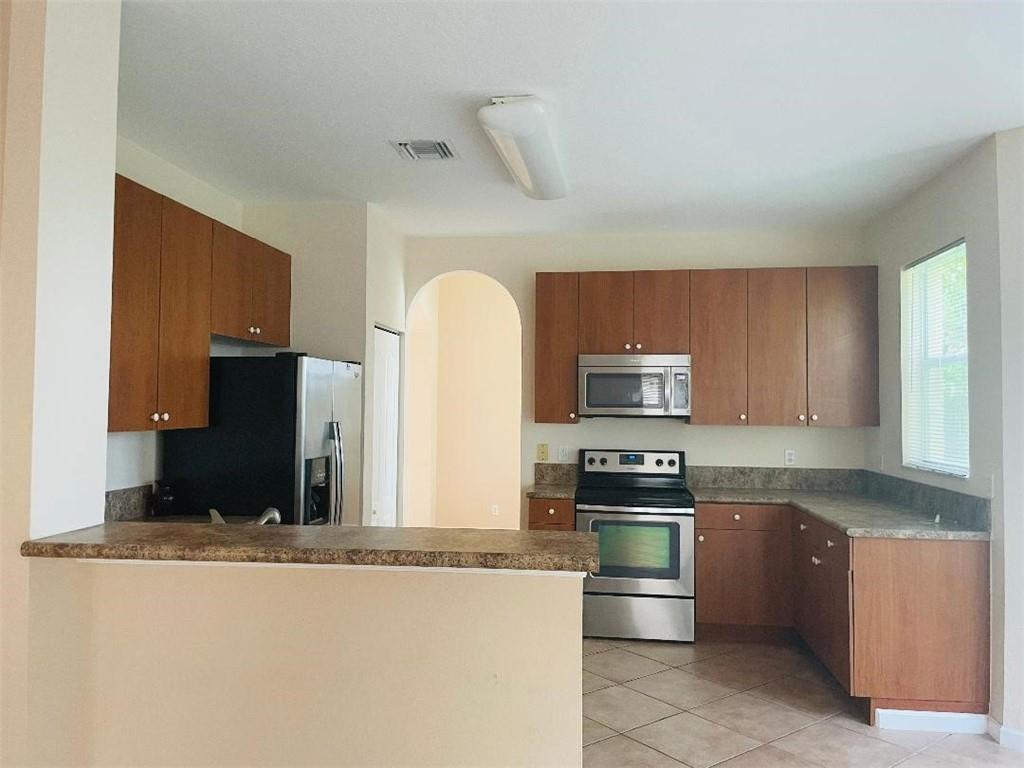 6008 Spring Lake Terrace Fort Pierce, FL 34951 - Photo 25 of 33 a kitchen with granite countertop a stove and a refrigerator