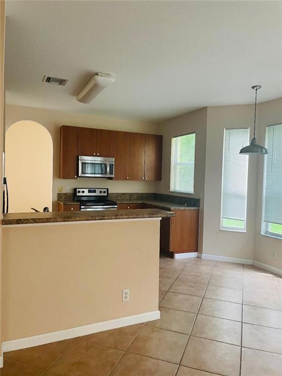 6008 Spring Lake Terrace Fort Pierce, FL 34951 - Photo 26 of 33 a kitchen with stainless steel appliances granite countertop a stove a sink and a microwave