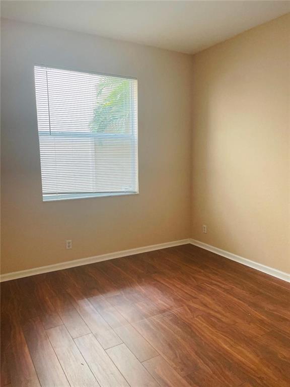 6008 Spring Lake Terrace Fort Pierce, FL 34951 - Photo 29 of 33 an empty room with wooden floor and windows