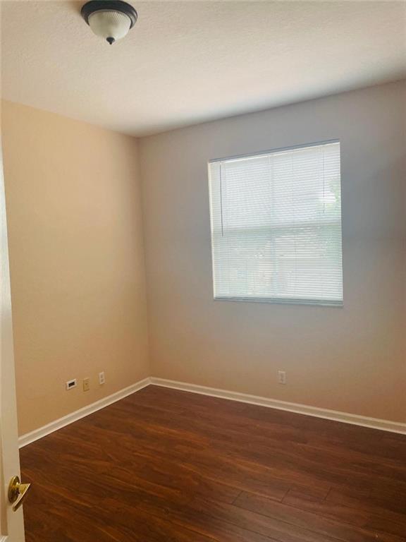 6008 Spring Lake Terrace Fort Pierce, FL 34951 - Photo 9 of 33 an empty room with wooden floor and windows