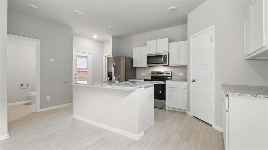 a kitchen with kitchen island a sink stainless steel appliances and cabinets