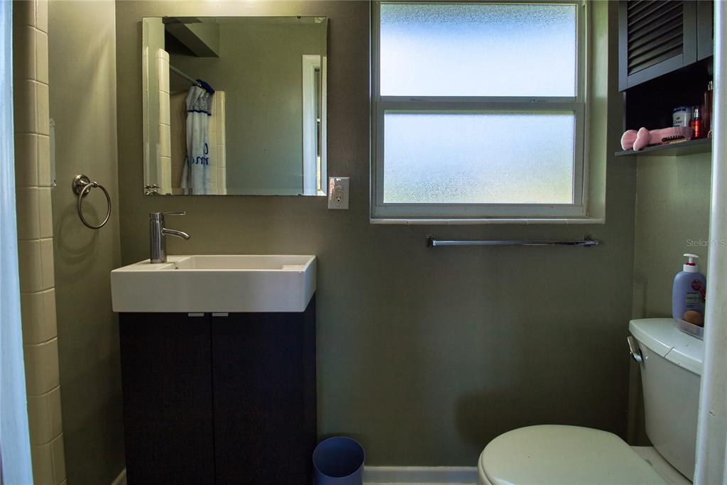 12784 137th Lane Largo, FL 33774 - Photo 12 of 14 a bathroom with a toilet a sink and mirror