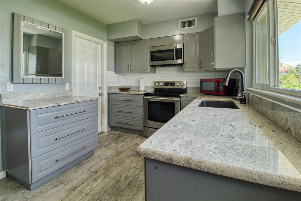 12784 137th Lane Largo, FL 33774 - Photo 2 of 14 a kitchen with a stove and a sink