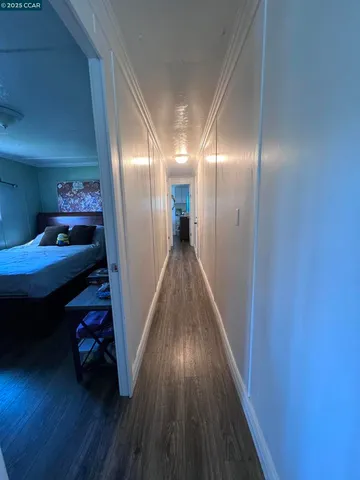 a view of a hallway with wooden floor and closet