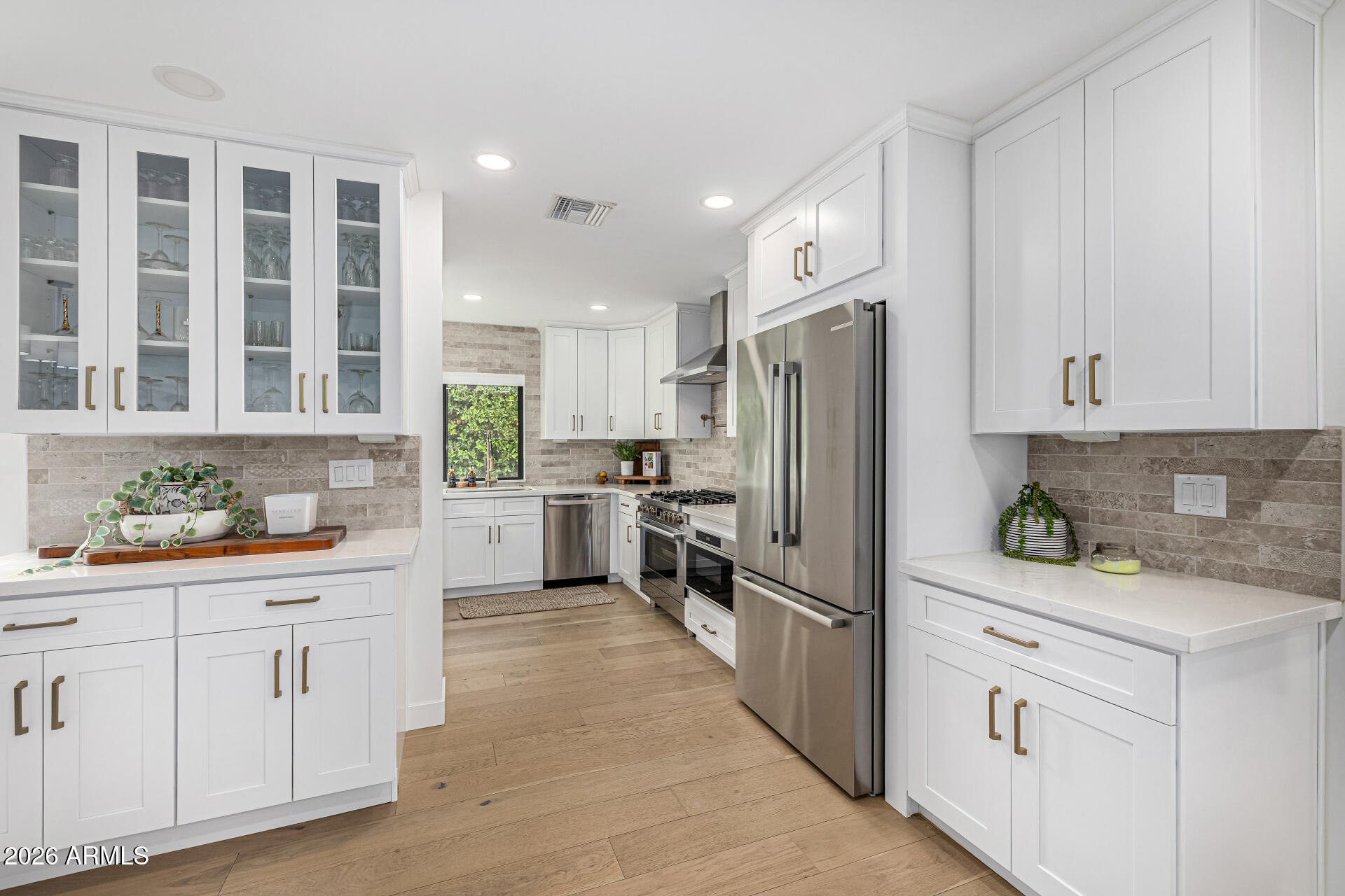 7770 East Camelback Road, Unit 11 Scottsdale, AZ 85251 - Photo 17 of 60 a kitchen with white cabinets and stainless steel appliances