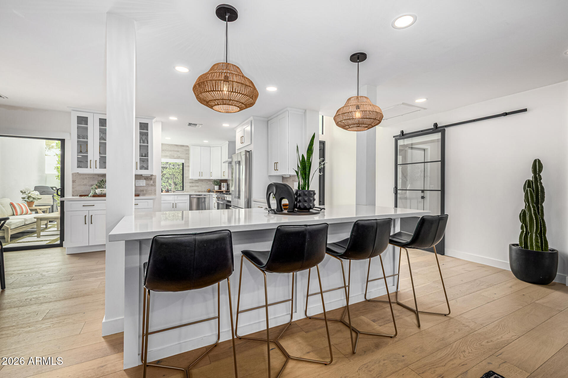 7770 East Camelback Road, Unit 11 Scottsdale, AZ 85251 - Photo 24 of 60 a kitchen with stainless steel appliances kitchen island granite countertop a stove a refrigerator a sink a dining table and chairs with wooden floor