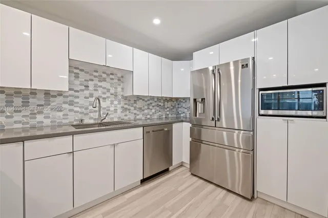 a view of a kitchen with white cabinets and wooden floor