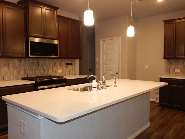 7103 Silverleaf Oak Street Conroe, TX 77304 - Photo 10 of 20 a kitchen with a sink a stove and a microwave