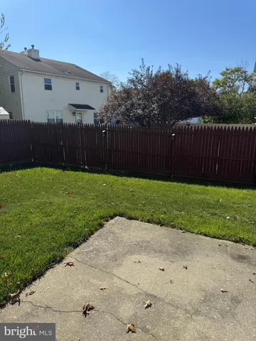 a view of a backyard with wooden fence