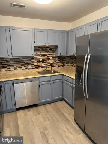 a kitchen with stainless steel appliances a refrigerator sink and cabinets