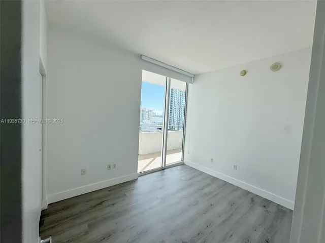 an empty room with wooden floor and a window