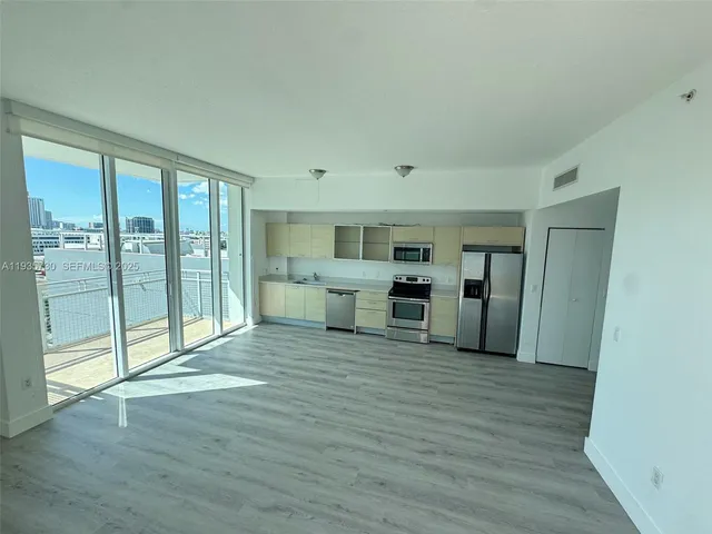a view of a kitchen with furniture and wooden floor