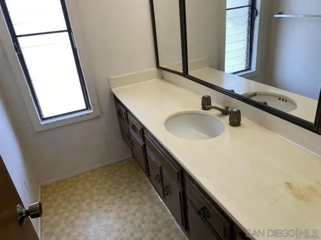 a bathroom with a double vanity sink and a mirror
