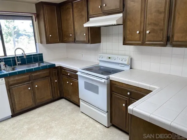 a kitchen with a stove sink and cabinets