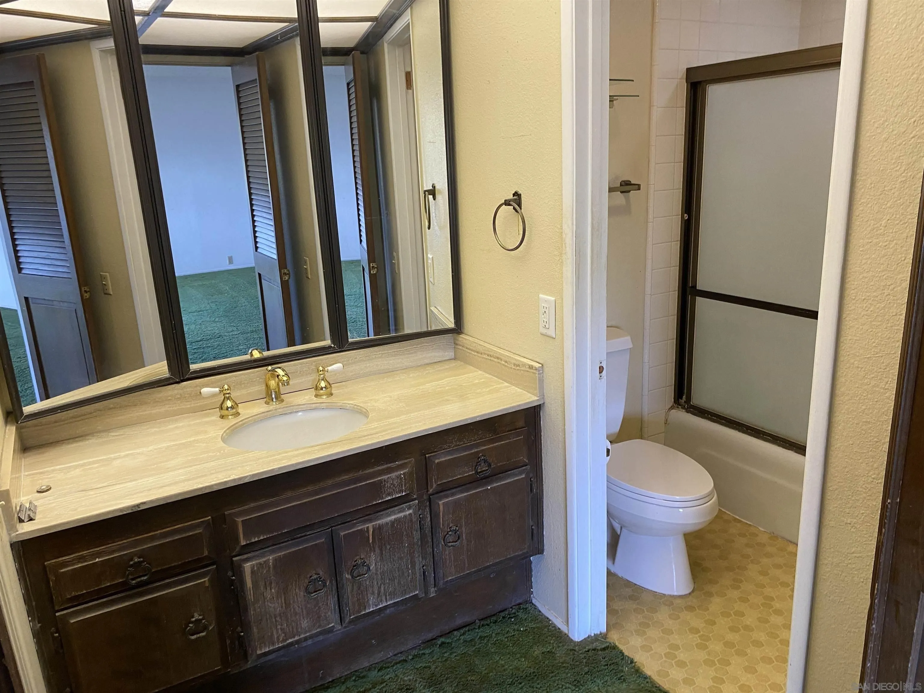 4940 Defiance Way San Diego, CA 92115 - Photo 32 of 47 a bathroom with a double vanity sink toilet and shower