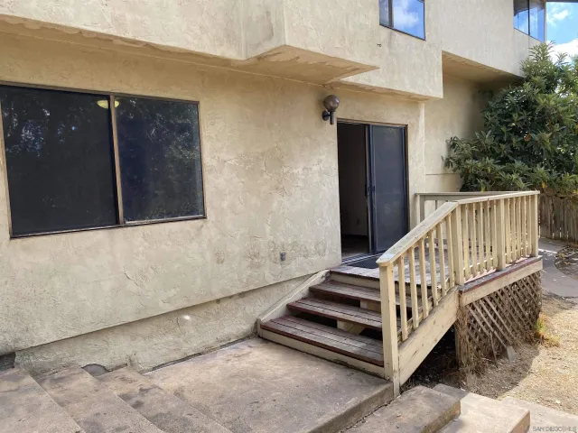 a side view of a house with a wooden fence
