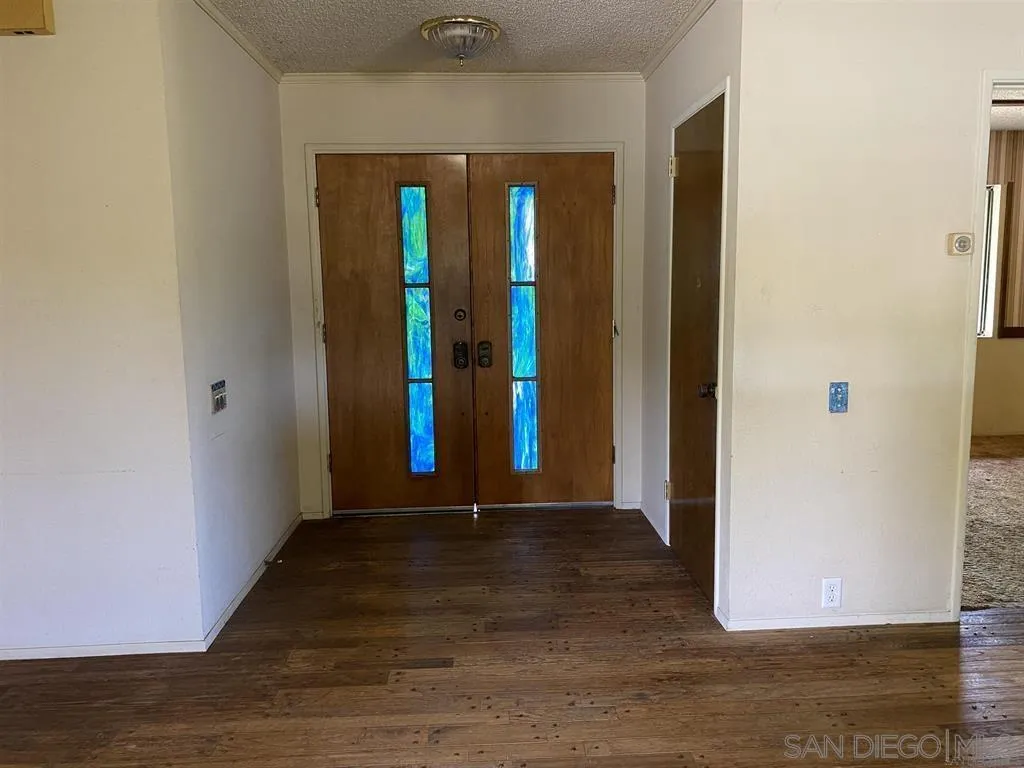 4940 Defiance Way San Diego, CA 92115 - Photo 7 of 47 a view of a hallway with wooden floor and a room