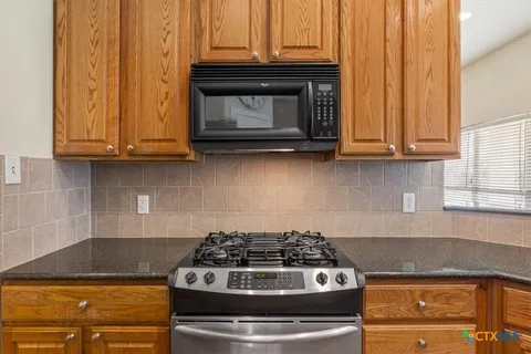 a stove top oven sitting inside of a kitchen