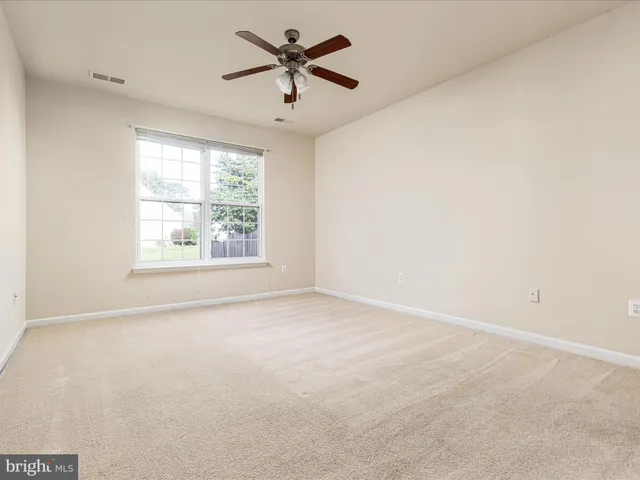 an empty room with a window and a fan