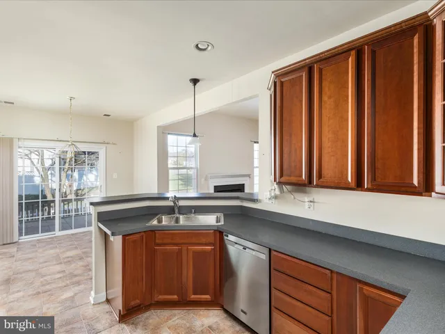 a kitchen with stainless steel appliances granite countertop wooden cabinets a sink and a large window