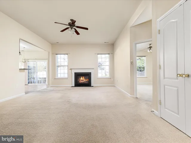 an empty room with windows and fireplace