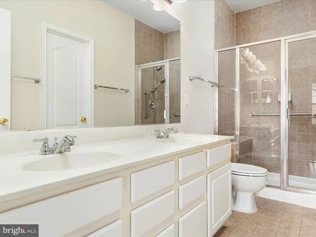 a bathroom with a double vanity sink toilet and shower