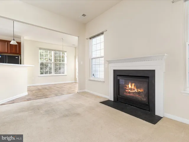 a view of an empty room with a fireplace and a window